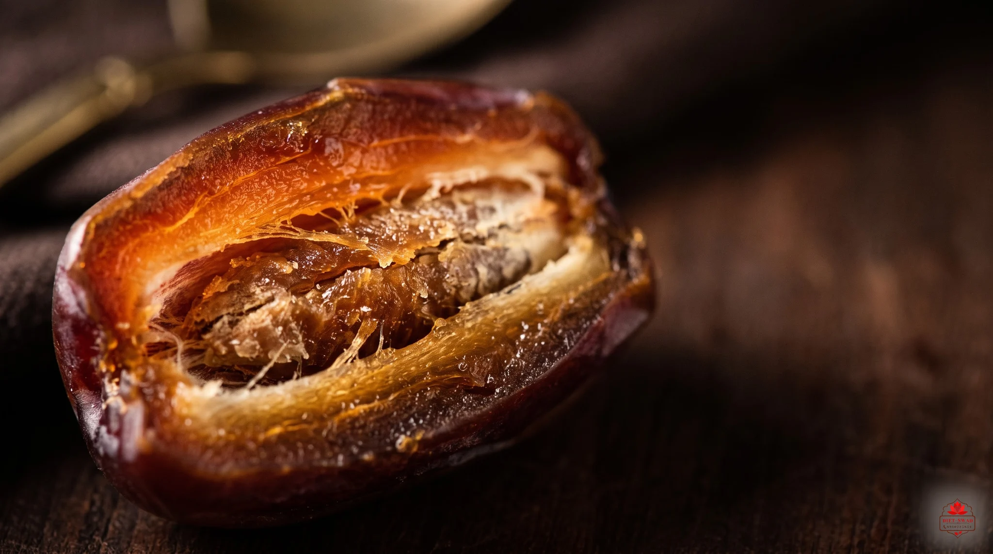 Extreme macro of a halved date, its fibrous flesh glowing amber against a dark background