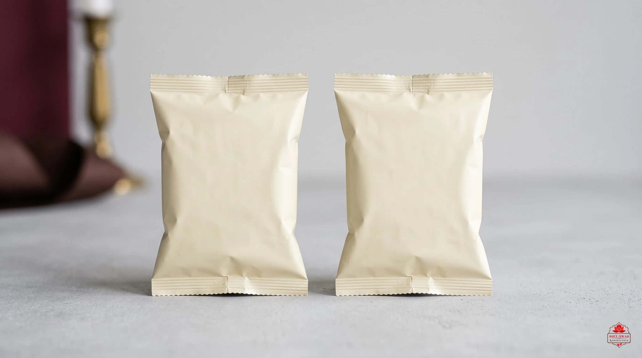 Two completely plain unbranded snack packets standing side by side on a pale surface